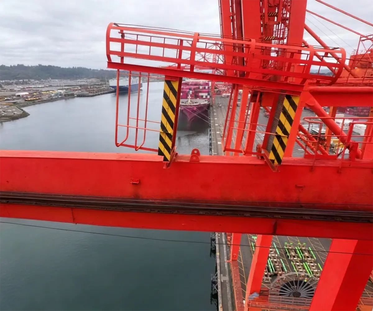 Rail-mounted port crane with steel wheels on crane runway beam